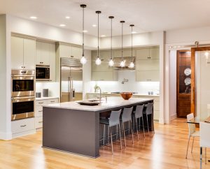 Kök interiör med ö, handfat, skåp och trägolv i New Luxury Home